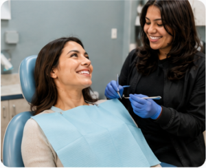 Smiling dental patient reassured by her hygienist during a deep cleaning appointment