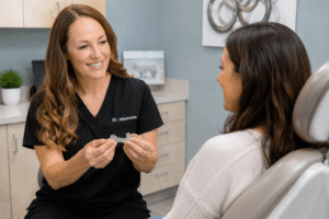 Dr. Mentesana holds a custom night guard while consulting with a patient about teeth grinding protection