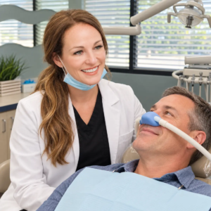 Relaxed patient receives nitrous oxide while a dentist provides reassurance at All Smiles Dentistry in Allen, Texas.