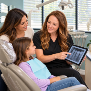 Dr. Mentesana explains a dental X-ray to a child and parent at All Smiles Dentistry in Allen, Texas